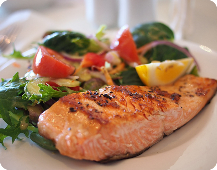 A plate of food with salmon and vegetables.
